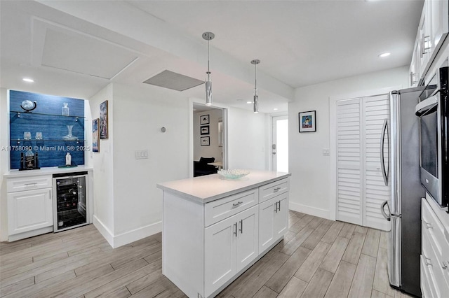 kitchen with wine cooler, stainless steel appliances, baseboards, white cabinets, and wood tiled floor