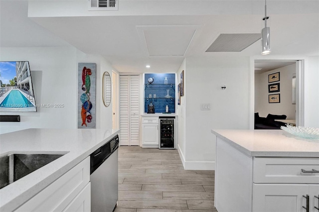 kitchen with visible vents, wine cooler, wood finish floors, white cabinetry, and stainless steel dishwasher