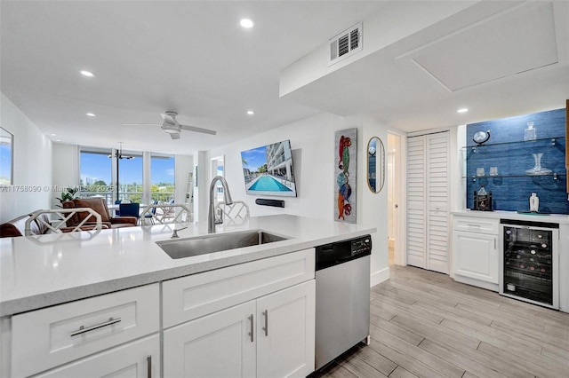 kitchen featuring beverage cooler, a sink, visible vents, light countertops, and dishwasher