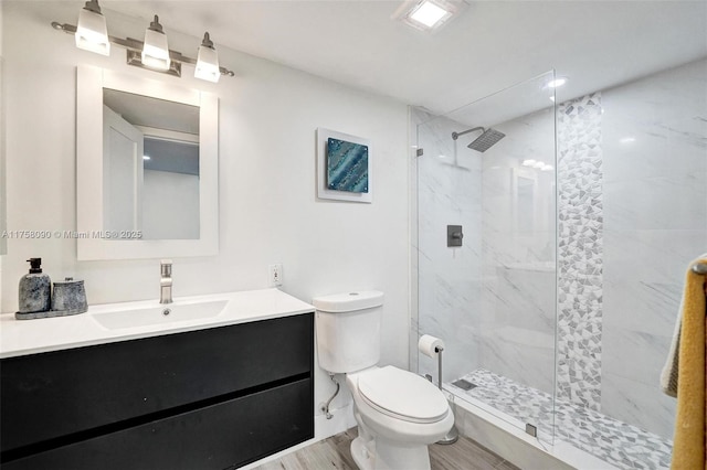 full bathroom featuring a stall shower, vanity, toilet, and wood finished floors