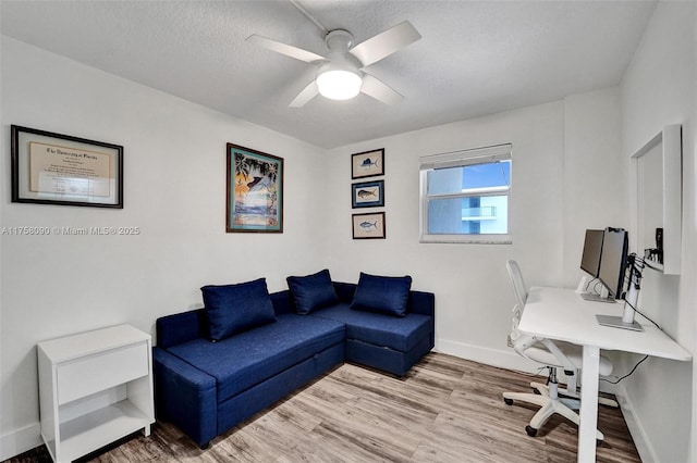 office with ceiling fan, a textured ceiling, light wood-type flooring, and baseboards