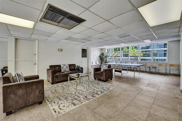 living area featuring a paneled ceiling and visible vents