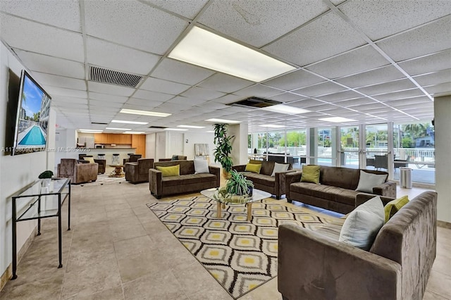 tiled living room featuring a paneled ceiling and visible vents