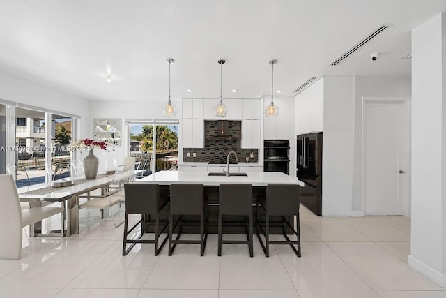 kitchen with modern cabinets, a sink, light countertops, white cabinetry, and backsplash