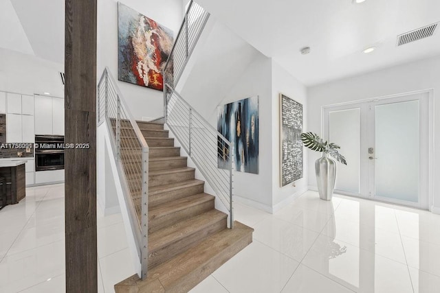 stairs with baseboards, recessed lighting, visible vents, and tile patterned floors