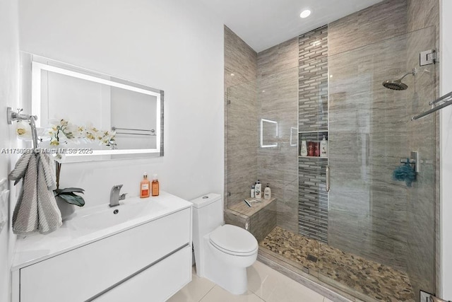 bathroom featuring a stall shower, tile patterned flooring, vanity, and toilet