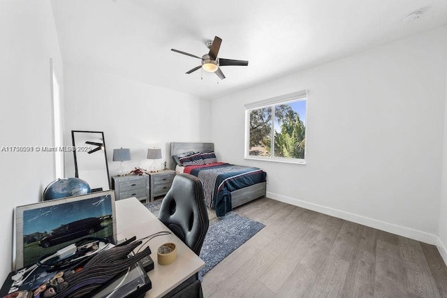 bedroom featuring a ceiling fan, baseboards, and wood finished floors