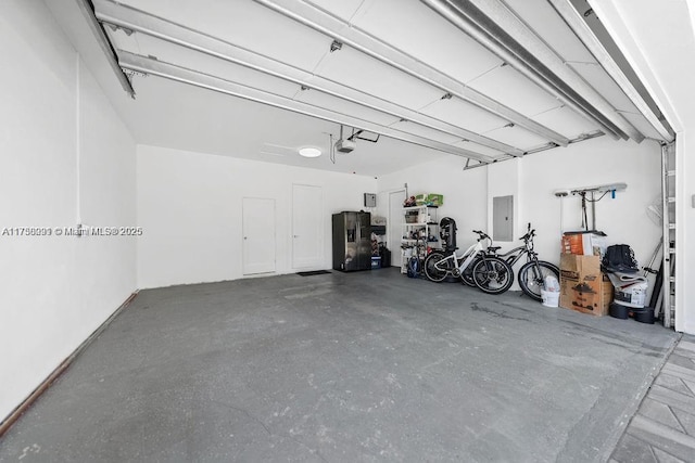 garage featuring electric panel, stainless steel refrigerator with ice dispenser, and a garage door opener