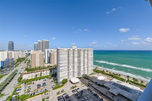 drone / aerial view with a water view, a view of city, and a beach view