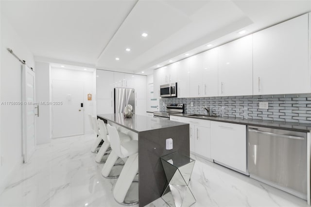 kitchen featuring dark countertops, marble finish floor, modern cabinets, and appliances with stainless steel finishes