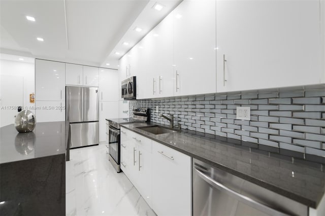 kitchen featuring marble finish floor, stainless steel appliances, white cabinets, a sink, and modern cabinets