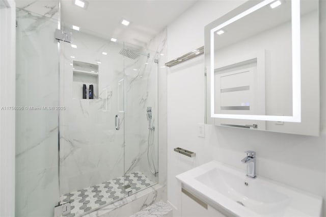 bathroom with a marble finish shower and vanity