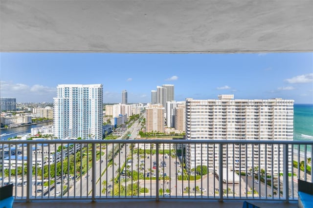 balcony with a water view and a view of city