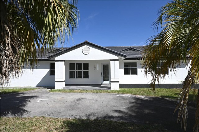 view of front of property featuring stucco siding, a porch, and a front lawn