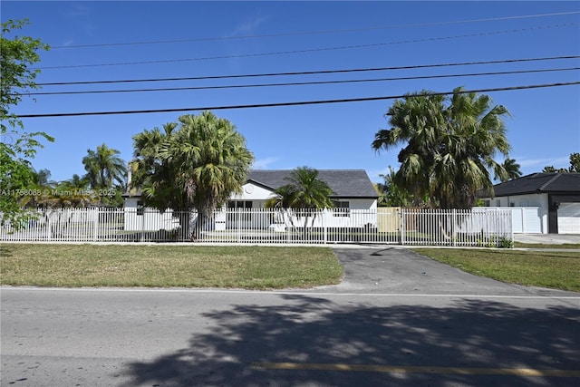 view of property hidden behind natural elements featuring a fenced front yard