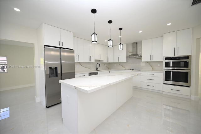 kitchen with visible vents, backsplash, a center island, wall chimney range hood, and appliances with stainless steel finishes