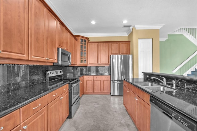 kitchen with stainless steel appliances, a sink, visible vents, dark stone counters, and brown cabinetry