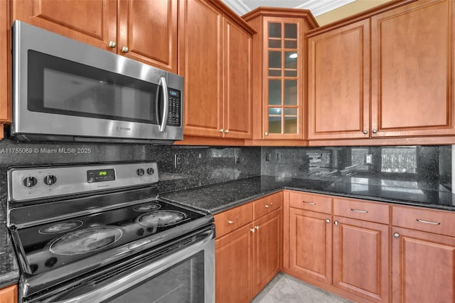 kitchen with brown cabinetry, tasteful backsplash, and stainless steel appliances