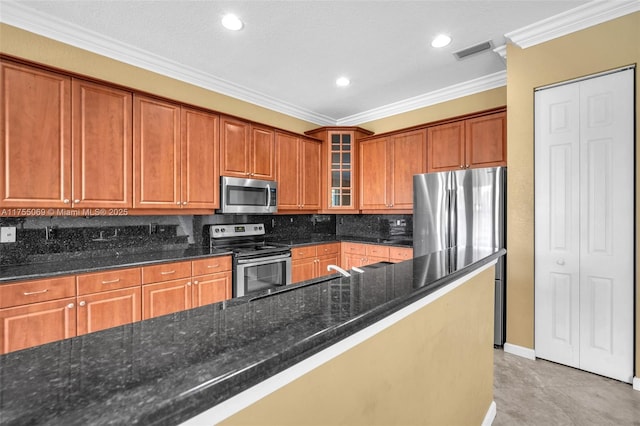 kitchen featuring visible vents, appliances with stainless steel finishes, decorative backsplash, brown cabinetry, and crown molding