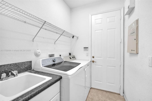 laundry area featuring laundry area, light tile patterned floors, a sink, and independent washer and dryer