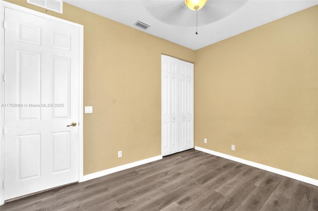 unfurnished bedroom with visible vents, baseboards, and wood finished floors