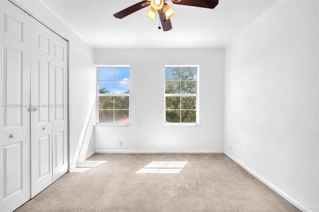 unfurnished bedroom featuring ceiling fan, a closet, carpet, and baseboards