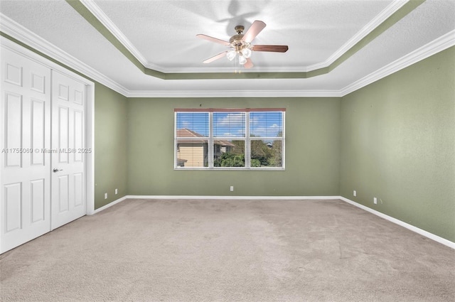 unfurnished bedroom featuring carpet floors, a textured ceiling, baseboards, and crown molding