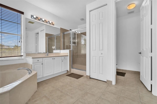 bathroom featuring tile patterned flooring, vanity, visible vents, a shower stall, and a bath