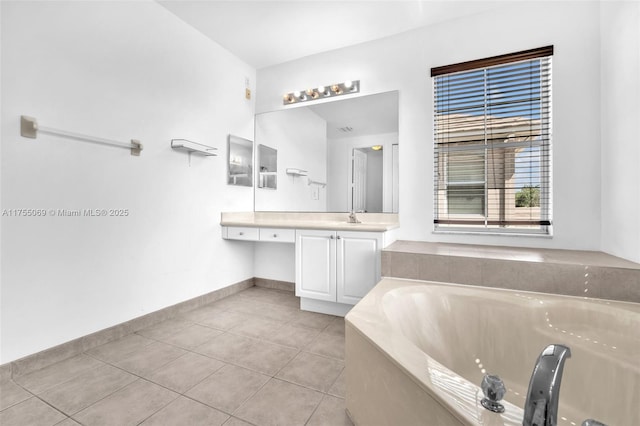 bathroom featuring a garden tub, vanity, baseboards, and tile patterned floors