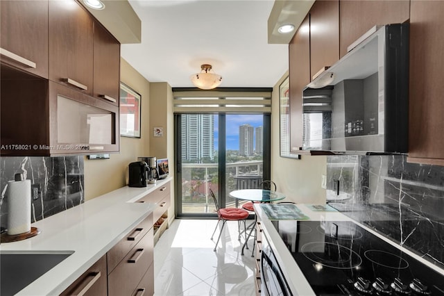 kitchen with black electric cooktop, stove, light countertops, backsplash, and floor to ceiling windows