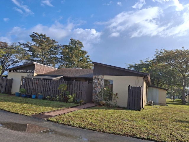 view of front of property featuring a front yard, fence, and stucco siding