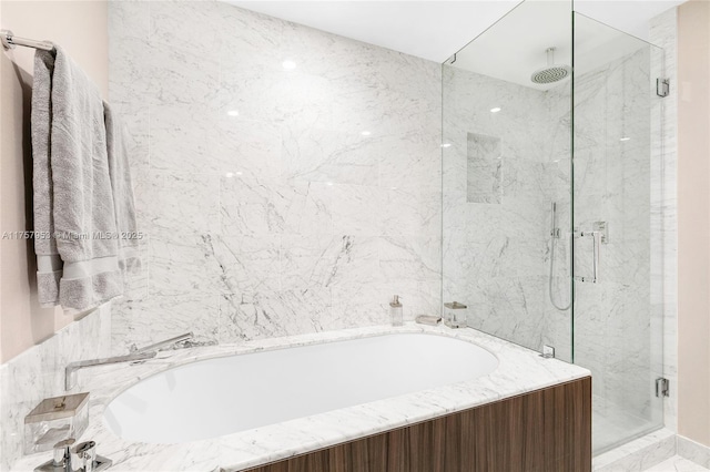 bathroom featuring a garden tub and a marble finish shower