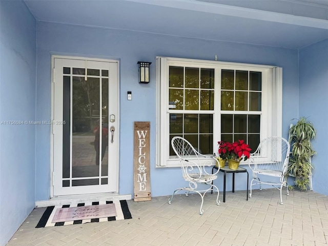 entrance to property featuring stucco siding