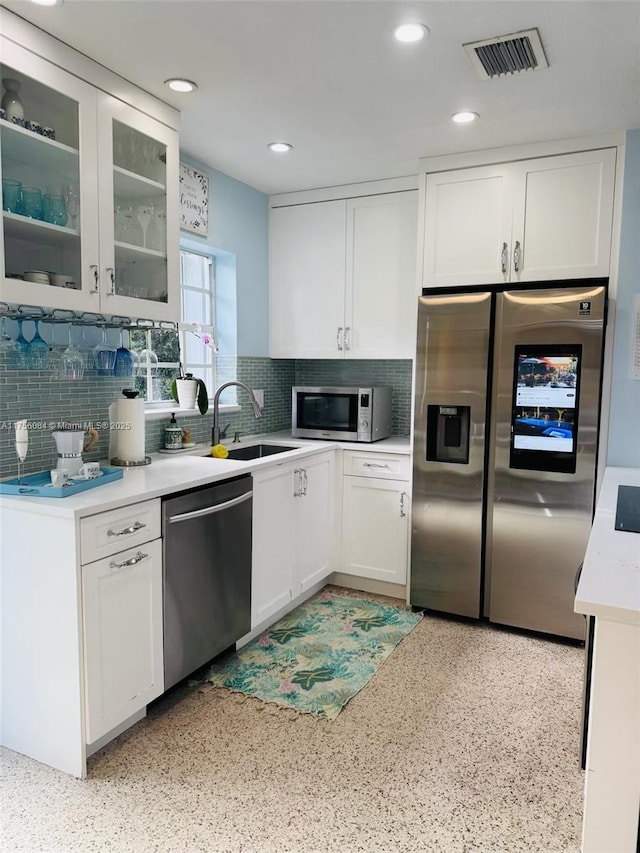 kitchen with visible vents, stainless steel appliances, light countertops, white cabinetry, and a sink