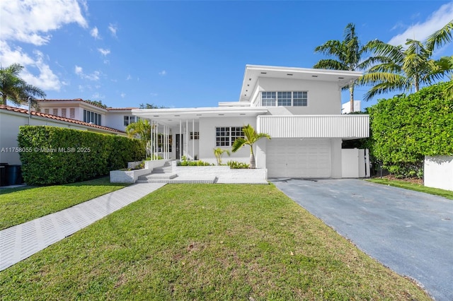 view of front facade featuring aphalt driveway, a garage, a front lawn, and stucco siding