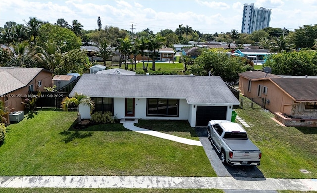 view of front of property with a garage, driveway, fence, a front lawn, and stucco siding