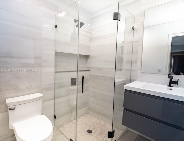 full bathroom featuring toilet, a stall shower, tile walls, and vanity