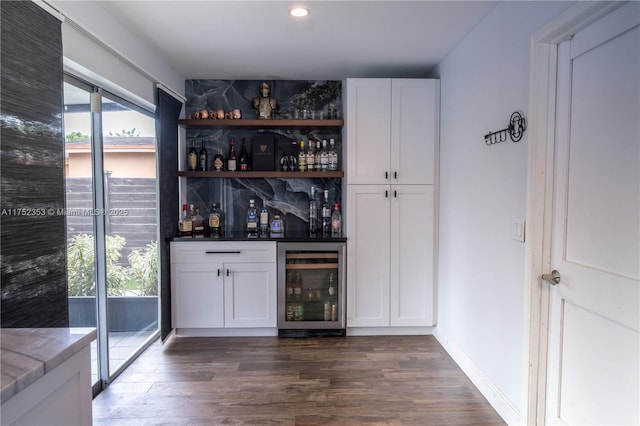 bar with a dry bar, beverage cooler, baseboards, dark wood-type flooring, and recessed lighting