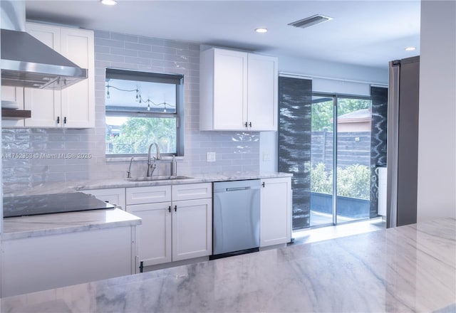 kitchen featuring visible vents, stainless steel dishwasher, a sink, stovetop, and extractor fan