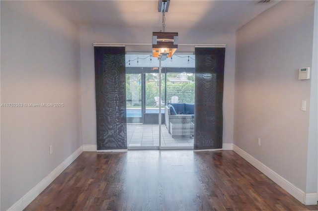 unfurnished room featuring baseboards and wood finished floors