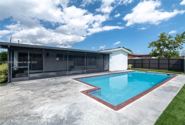 view of pool featuring a sunroom, a patio, fence, and a fenced in pool