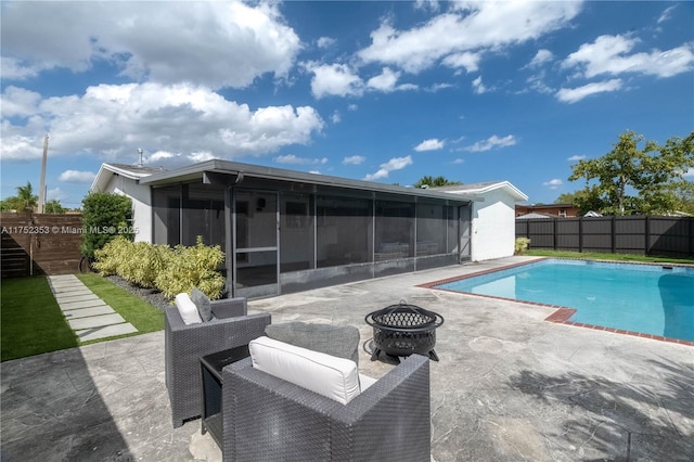 view of pool with a sunroom, a patio area, a fire pit, and a fenced backyard