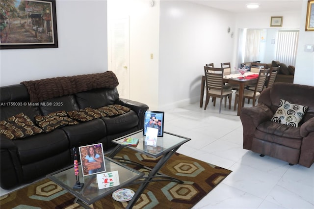 living area featuring marble finish floor and baseboards