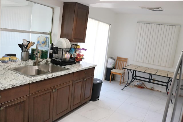 kitchen featuring marble finish floor, visible vents, and a sink