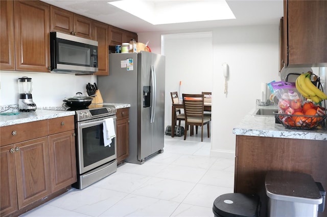 kitchen featuring appliances with stainless steel finishes and brown cabinets