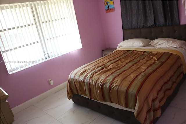 bedroom with marble finish floor and baseboards