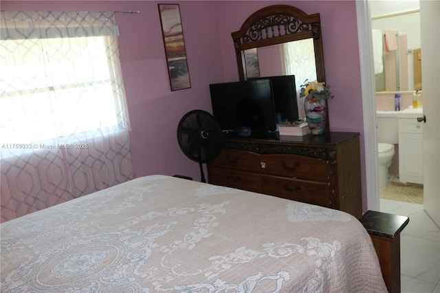 bedroom featuring multiple windows and ensuite bathroom