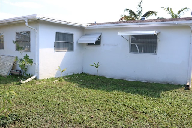 view of property exterior with a yard and stucco siding