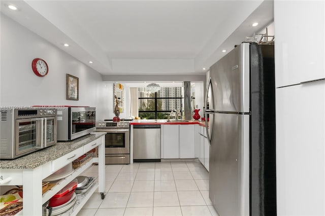 kitchen featuring light countertops, light tile patterned floors, recessed lighting, stainless steel appliances, and white cabinetry