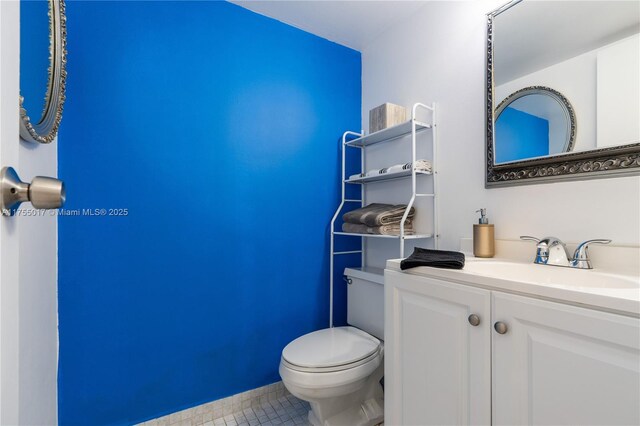 bathroom featuring toilet, vanity, and tile patterned flooring